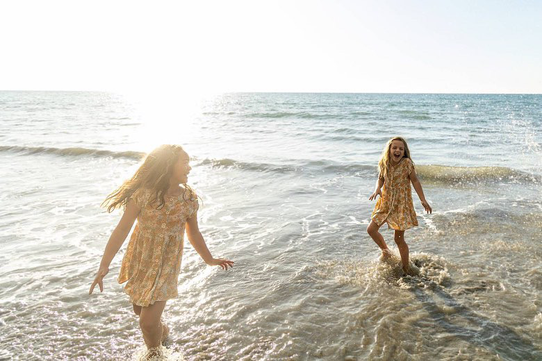 Two girls playing in water at beach